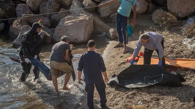 People pulling body from the sea at the beach