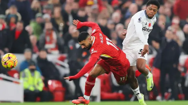 Mohamed Salah is fouled by Leon Bailey as he tries to run clear