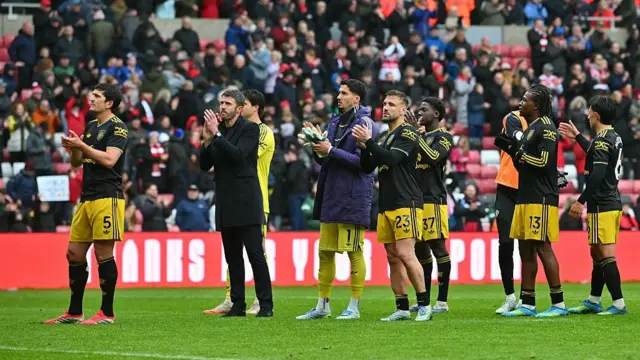 Manchester United's English Interim head coach Michael Carrick and players applauds the fans.