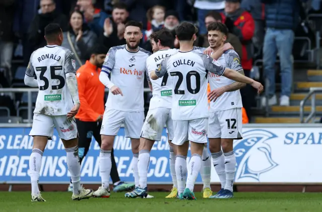 Swansea City's players celebrate a goal against Blackburn