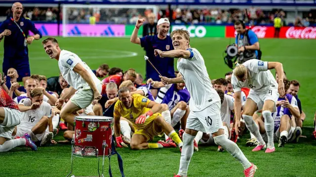 Martin Odegaard beats a drum in front of Norway's fans and players