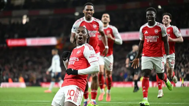 Eberechi Eze knee sliding with other Arsenal players running behind him