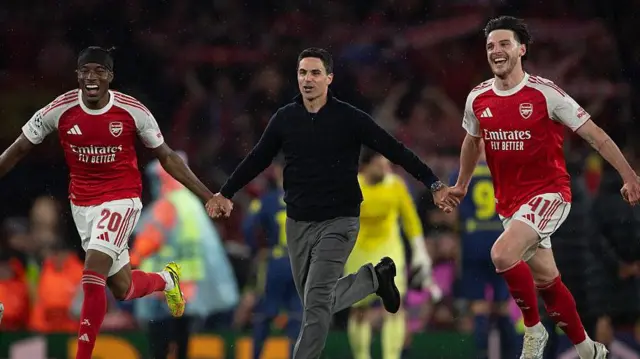 Noni Madueke, Mikel Arteta and Declan rice holding hands in celebration of making the Champions League final