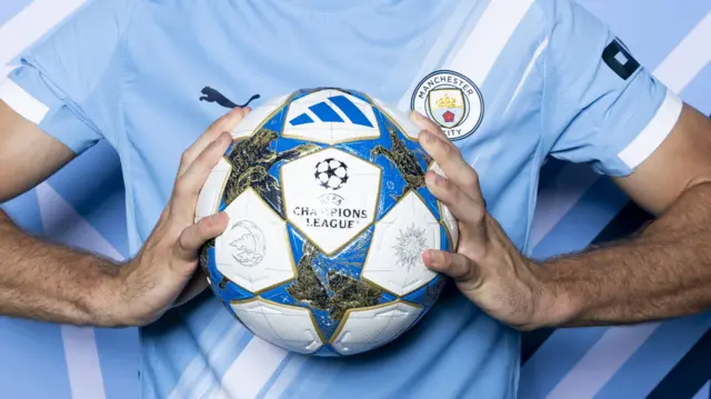 Close up of Manchester City player holding Champions League ball
