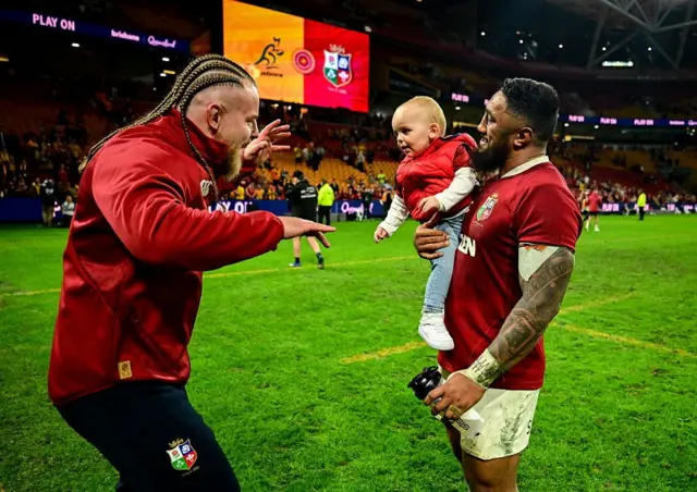 Finlay Bealham of British & Irish Lions, left, plays with his son Joaquin and teammate Bundee Aki after the first test match between Australia and the British & Irish Lions.