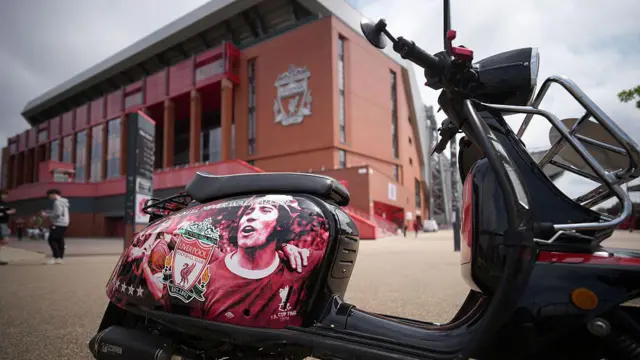A Liverpool supporter leaves a scooter dedicated to Kevin Keegan outside Anfield