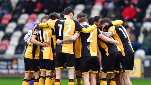 Newport County players in a group huddle