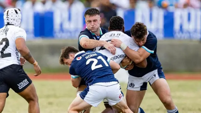 Fergus Burke, Tom Jordan and George Horne tackle a Fijian