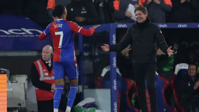 Oliver Glasner and Michael Olise celebrate on the touchline after his second goal against Manchester United