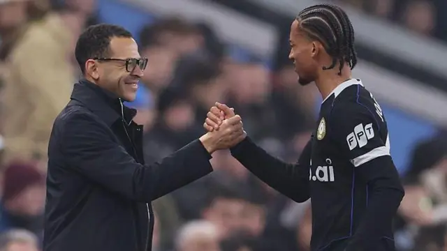 Liam Rosenior shaking hands with Joao Pedro after the forward came off the pitch in the 85th minute against Aston Villa