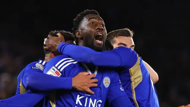 Wilfred Ndidi shouts as he is mobbed by Leicester players, wearing blue, after scoring a goal