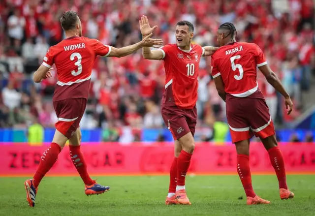 Silvan Widmer, Granit Xhaka and Manuel Akanji of Switzerland celebrate