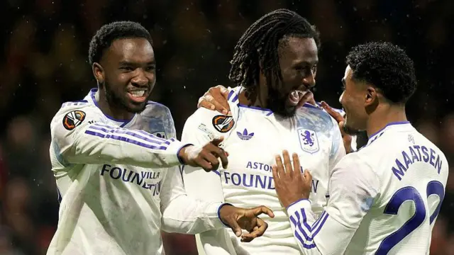 Evann Guessand of Aston Villa celebrates a goal with team-mates Lamare Bogarde and Ian Maatsen