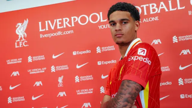 Jarell Quansah stands in front of Liverpool background