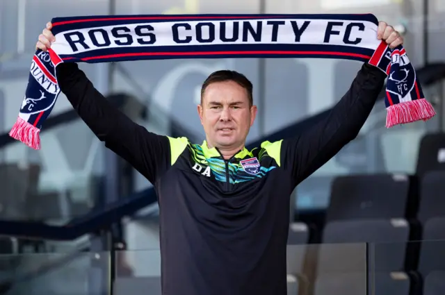 Manager Derek Adams holds aloft a Ross County scarf