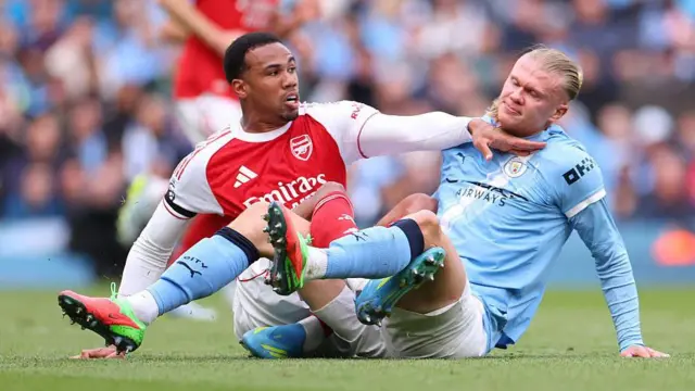 Gabriel Magalhaes of Arsenal grapples with Erling Haaland
