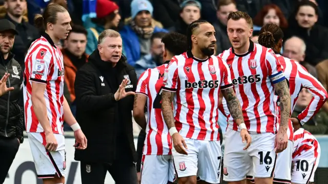 Mark Robins issues instructions to Stoke City players on the touchline during a game