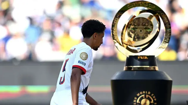 Marquinhos looks dejected as he walks past the Club World Cup trophy