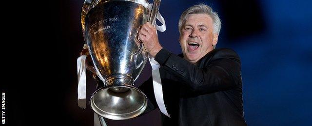 Head coach Carlo Ancelotti of Real Madrid CF holds the UEFA Champions League cup celebrating their victory on the UEFA Champions League Final match against Club Atletico de Madrid at Cibeles square on the early morning of May, 25, 2014