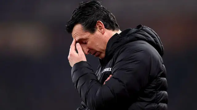 Unai Emery, wearing a black puffer jacket and looking dejected