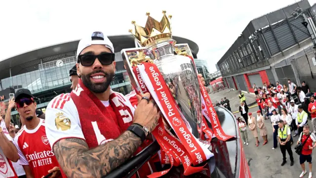 David Raya celebrates with the Premier League trophy 