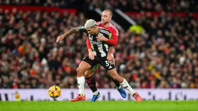 Bruno Guimares of Newcastle United jostles for the ball against Christian Eriksen of Manchester United during the Premier League match between Manchester United FC and Newcastle United FC at Old Trafford