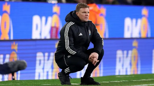 Eddie Howe squats on the touchline
