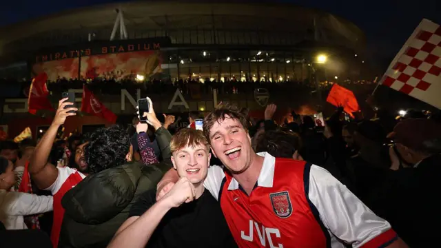 Arsenal fans celebrate outside the Emirates
