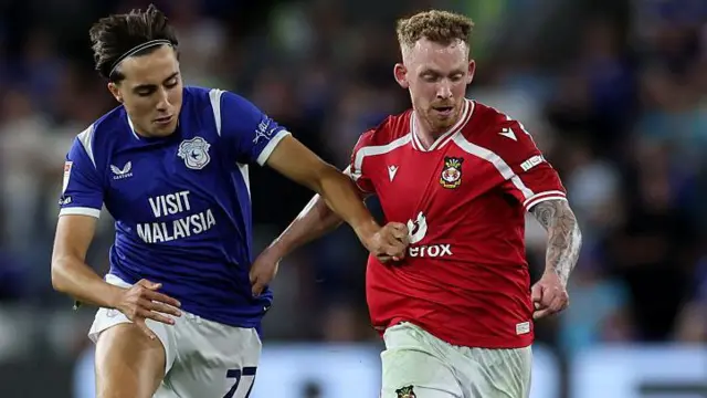 Wrexham midfielder Lewis O'Brien (right) runs beyond Cardiff City's Joel Colwill