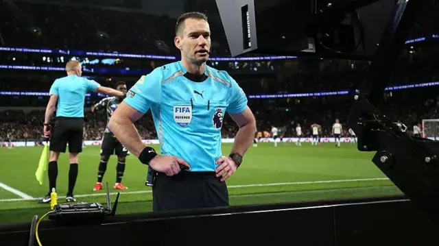 Jared Gillett consults a sideline monitor during a VAR check for a Leeds penalty against Tottenham in the Premier League earlier this month