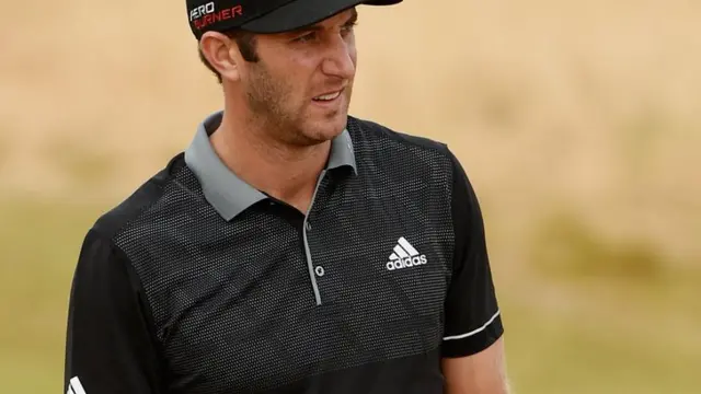 Dustin Johnson looks on