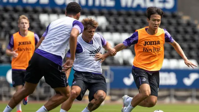 Eom Ji-Sung holds off Goncalo Franco in Swansea training