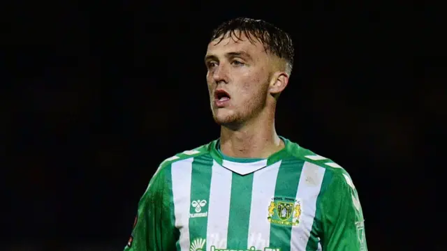 Jamie Andrews in action for Yeovil Town. He is wearing a green and white striped shirt.