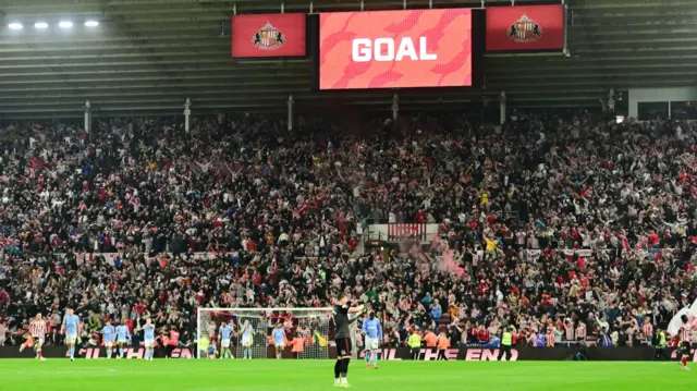 Sunderland players celebrate their last minute equaliser against Coventry with the stadium scoreboard showing 'Goal'