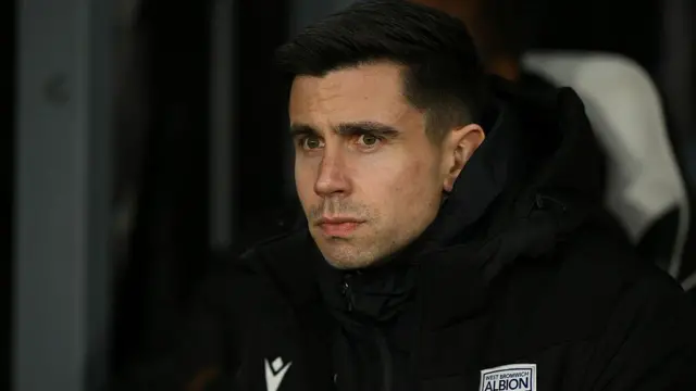 A pensive looking West Brom head coach Eric Ramsay watching his side while seated on the bench
