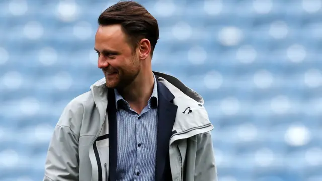 Christopher Vivell in a jacket and shirt