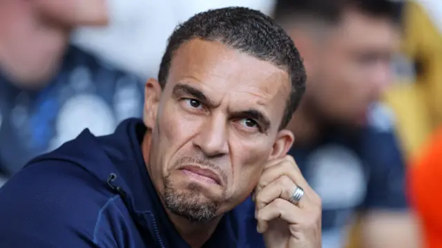 Valerien Ismael in the dugout at West Brom with his hand on his left ear 
