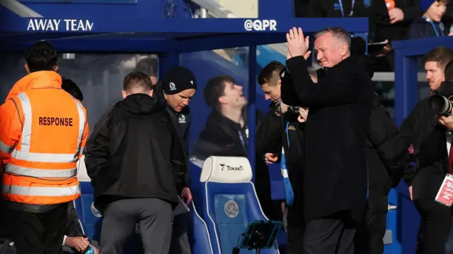 Michael O'Neill applauding his players from the dugout in an all-black outfit