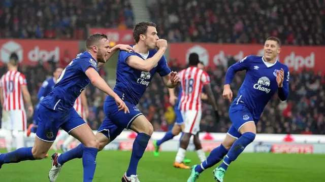 Seamus Coleman celebrates a goal and is mobbed by players. He sucks his thumb to celebrate the goal.