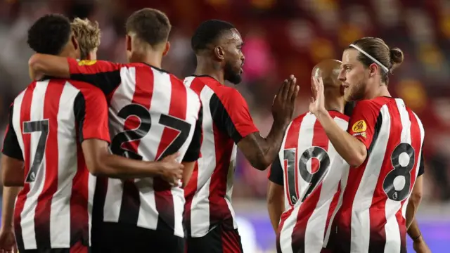 Brentford players celebrate a goal scored against Wolfsburg