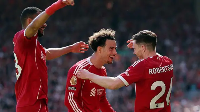 Curtis Jones celebrates with Andy Robertson and Cody Gakpo