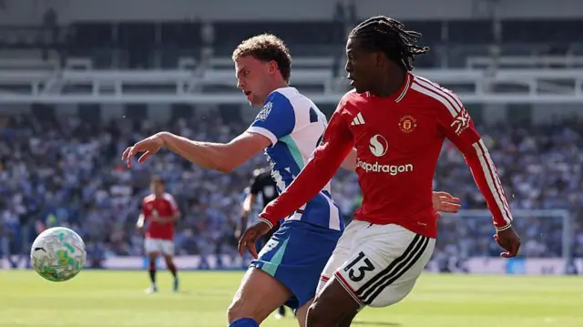 Patrick Dorgu battles for possession with Brighton's Mats Wieffer