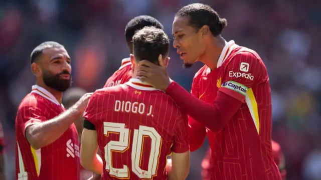 Virgil van Dijk embraces Diogo Jota on the pitch