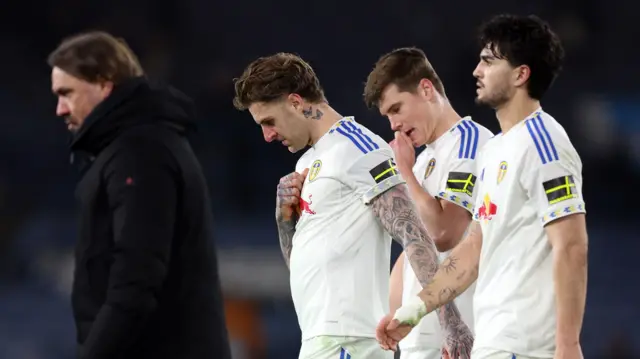 Leeds players and manager look dejected walking off pitch