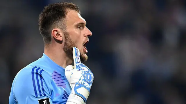 Goalkeeper Lucas Perri touches his face