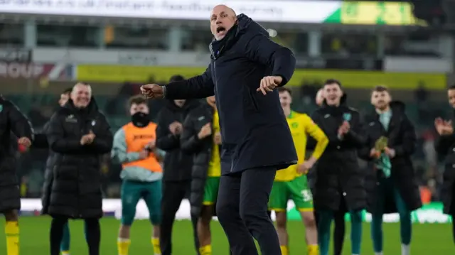 Norwich boss Philippe Clement celebrates in front of the home fans with his players stood behind him