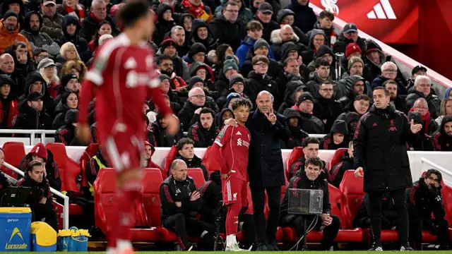 Liverpool head coach Arne Slot talks to substitute Trent Kone-Doherty