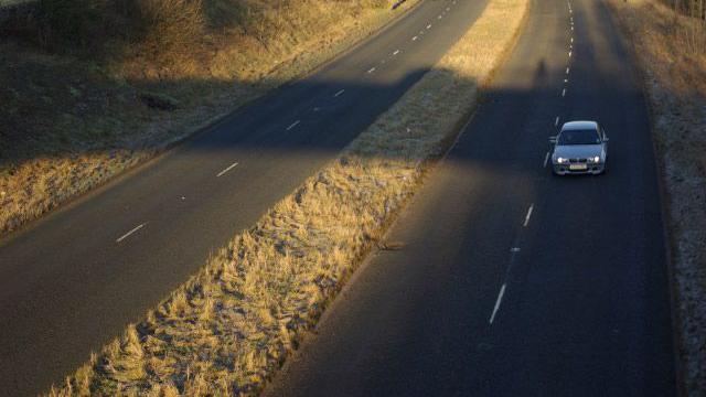 The A591 by-passes Kendal to the west providing a route into the Lake District for traffic off the M6. It is seen here from the Brigsteer Road bridge on a cold morning. There is one car travelling south.