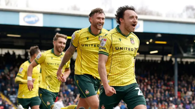 Wrexham's Ollie Rathbone (right) celebrates with Dan Scarr (second right) and Sam Smith (left)