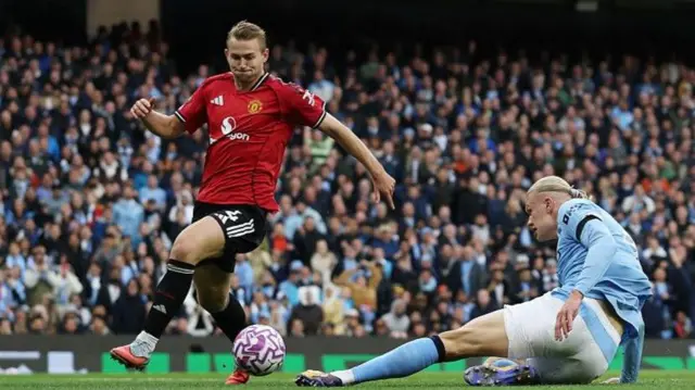 Manchester United defender Matthijs de Ligt tries to challenge Manchester City striker Erling Haaland